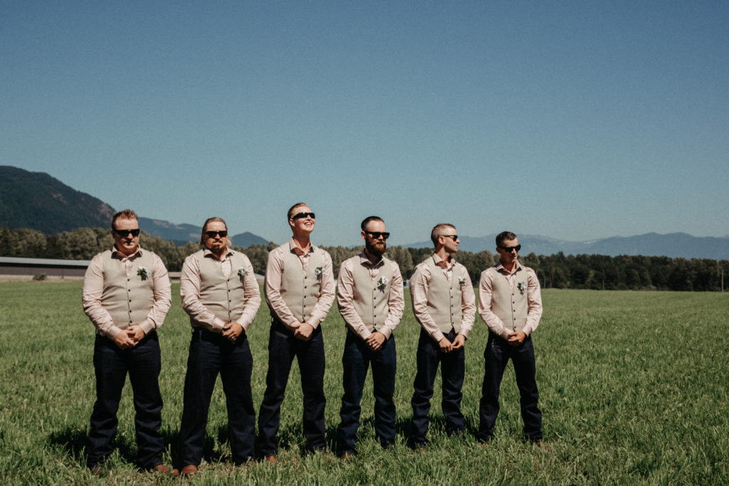 groomsmen standing in front of mountains at the ceremony