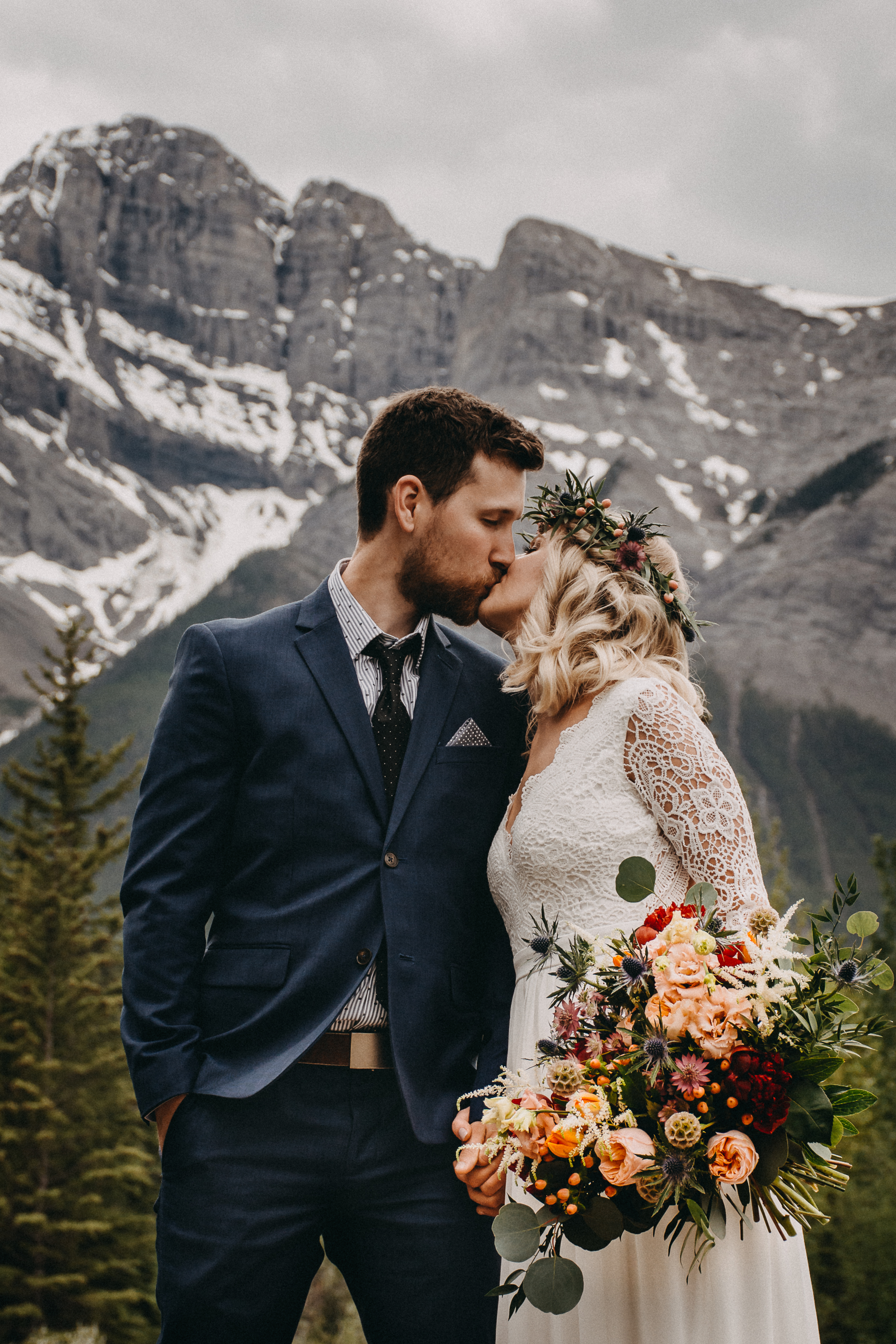 Bride and Groom kissing in front of the rocky mountains