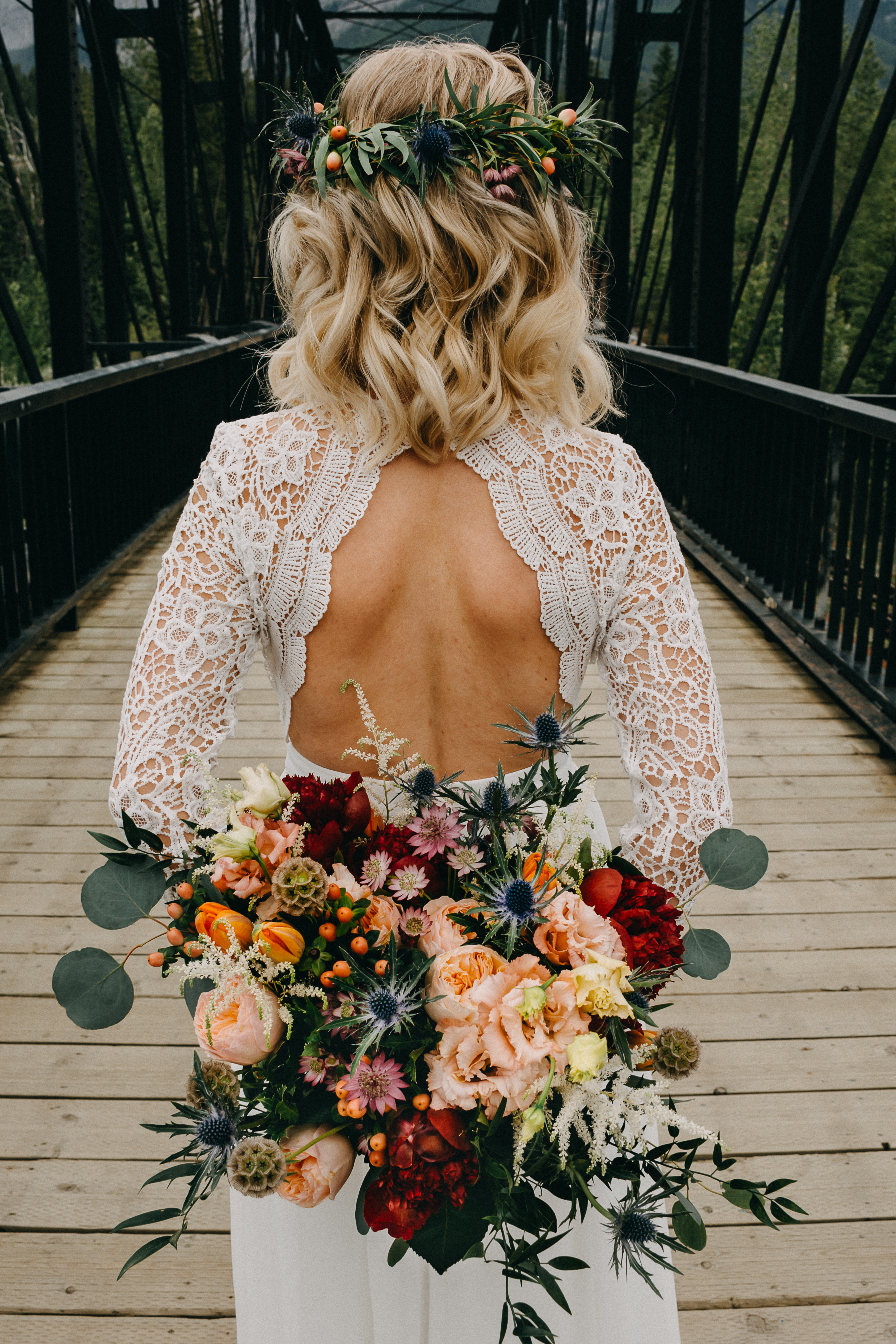 The bride holding her bouquet behind her back on the engine bridge in Canmore, Alberta