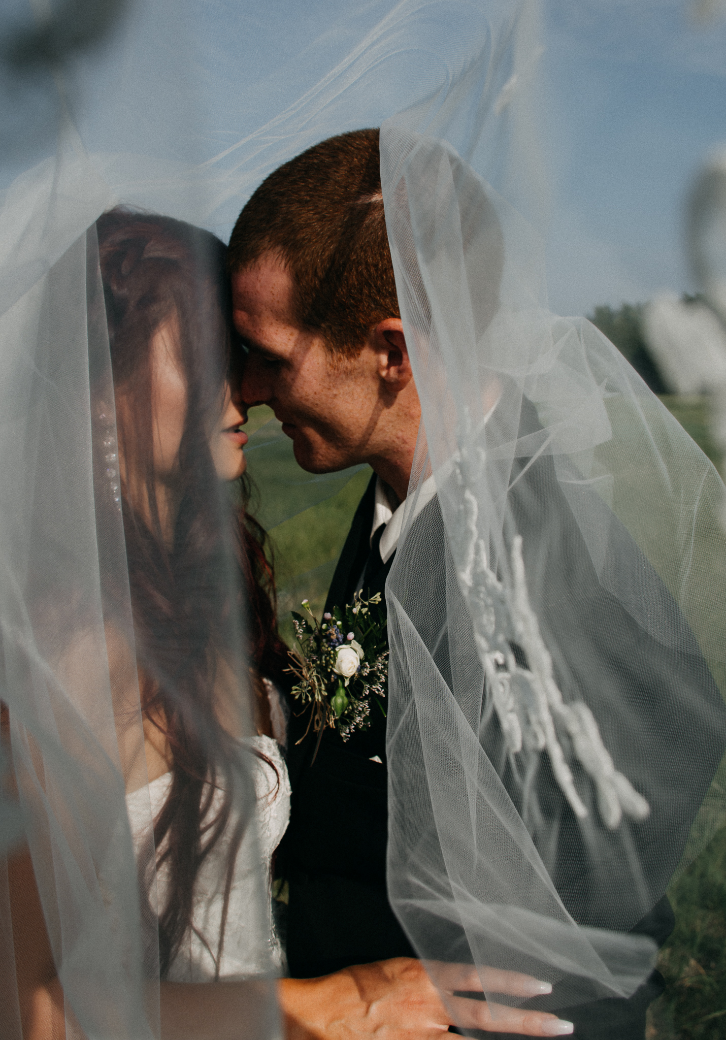 bride and groom getting intimate under veil