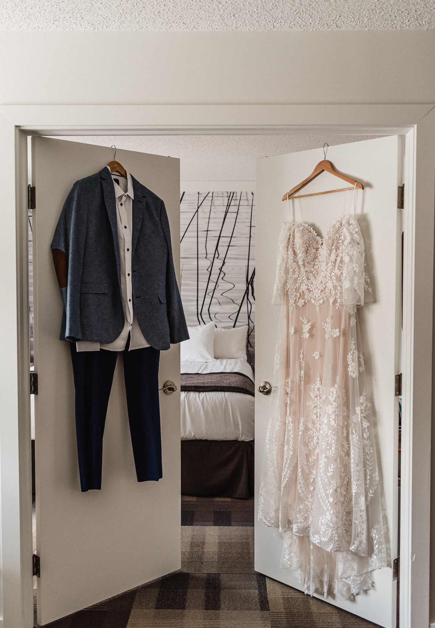 Suit and bridal gown hanging on separate doors at Coast Canmore Hotel, Alberta