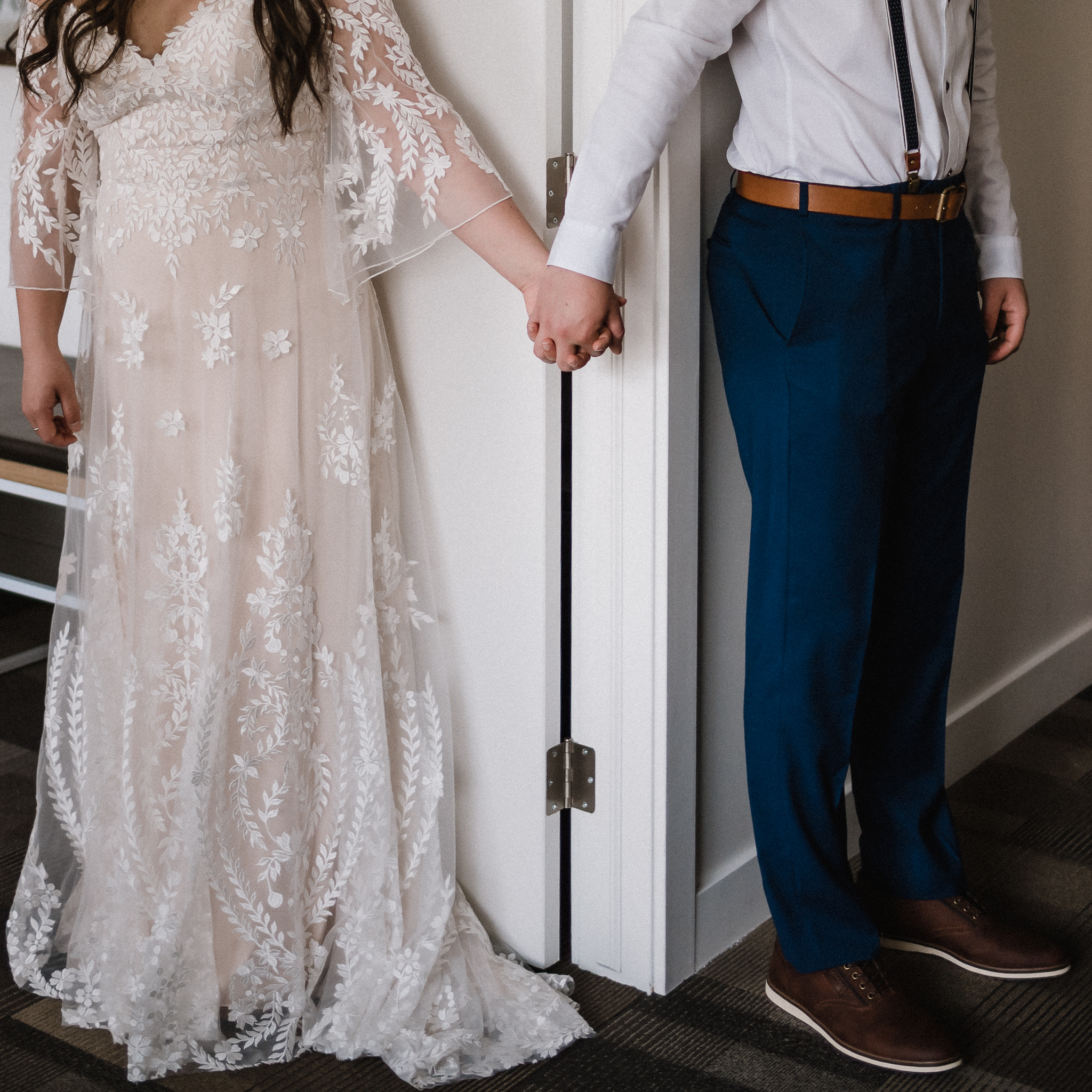 Close up of bride and groom holding hands at Coast Canmore Hotel, Alberta
