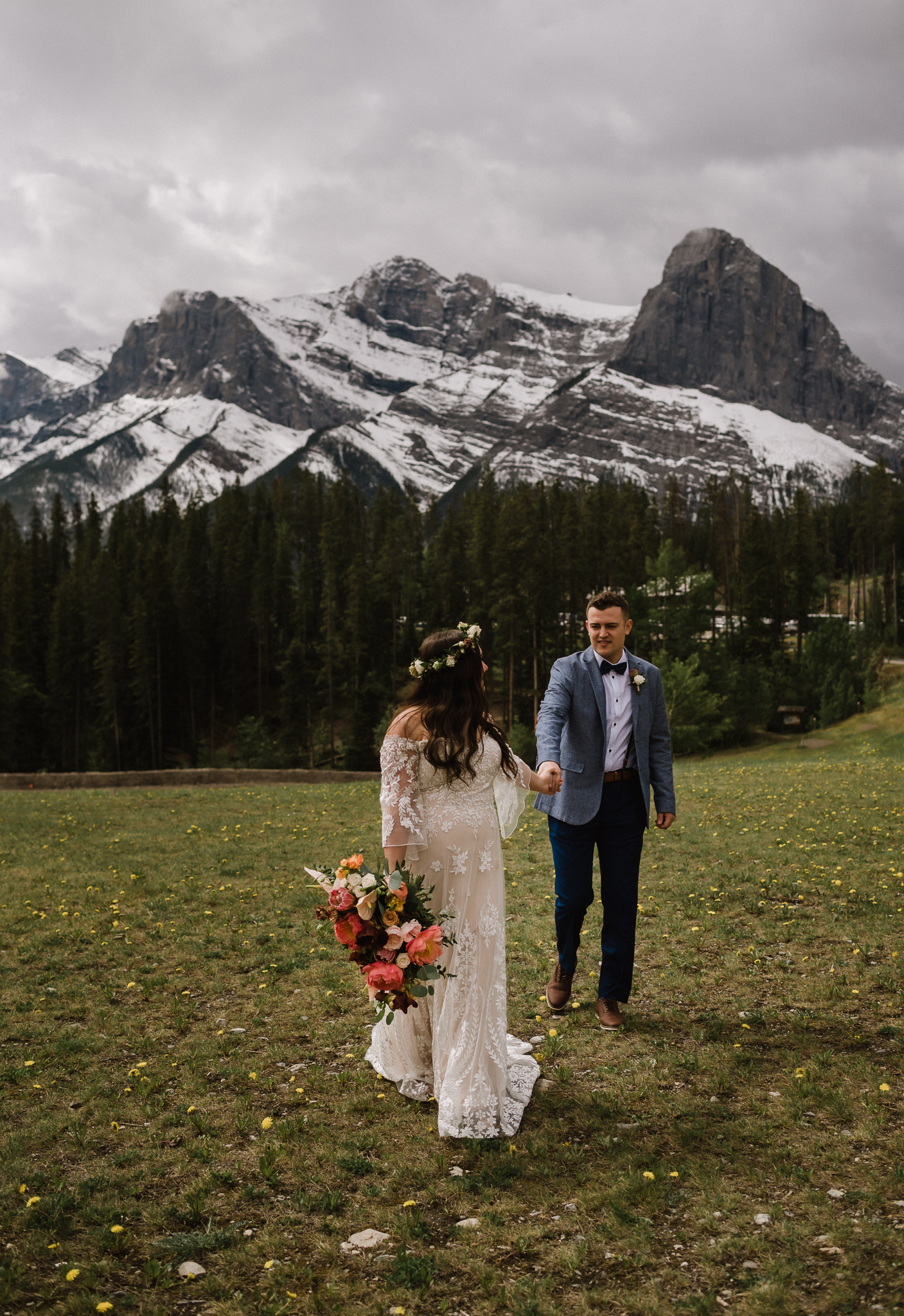 Bride pulling groom towards her at the Nordic Center, Canmore