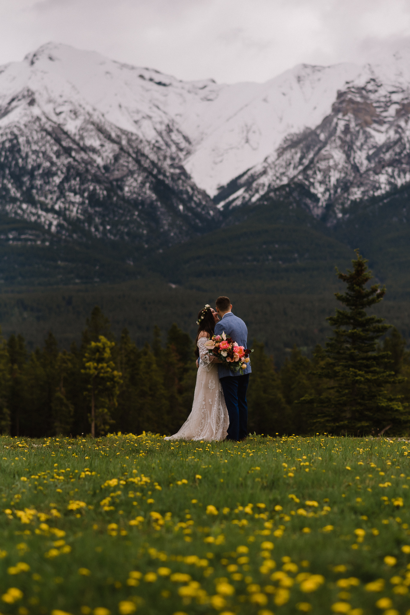 Portrait of bride and groom in front of mountains at the Nordic Center, Canmore