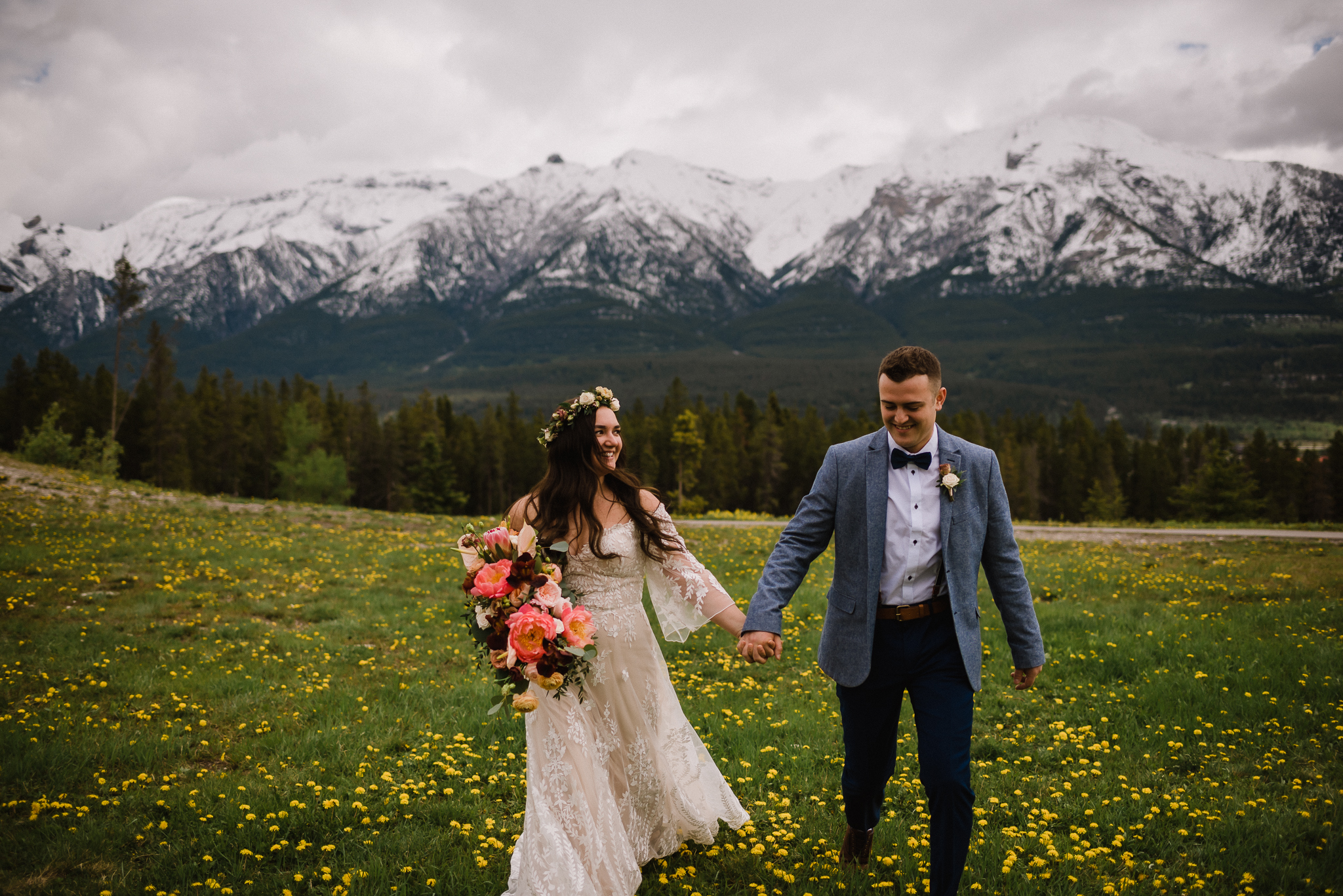 Bride and groom holding hands while walking at the Nordic Center, Canmore