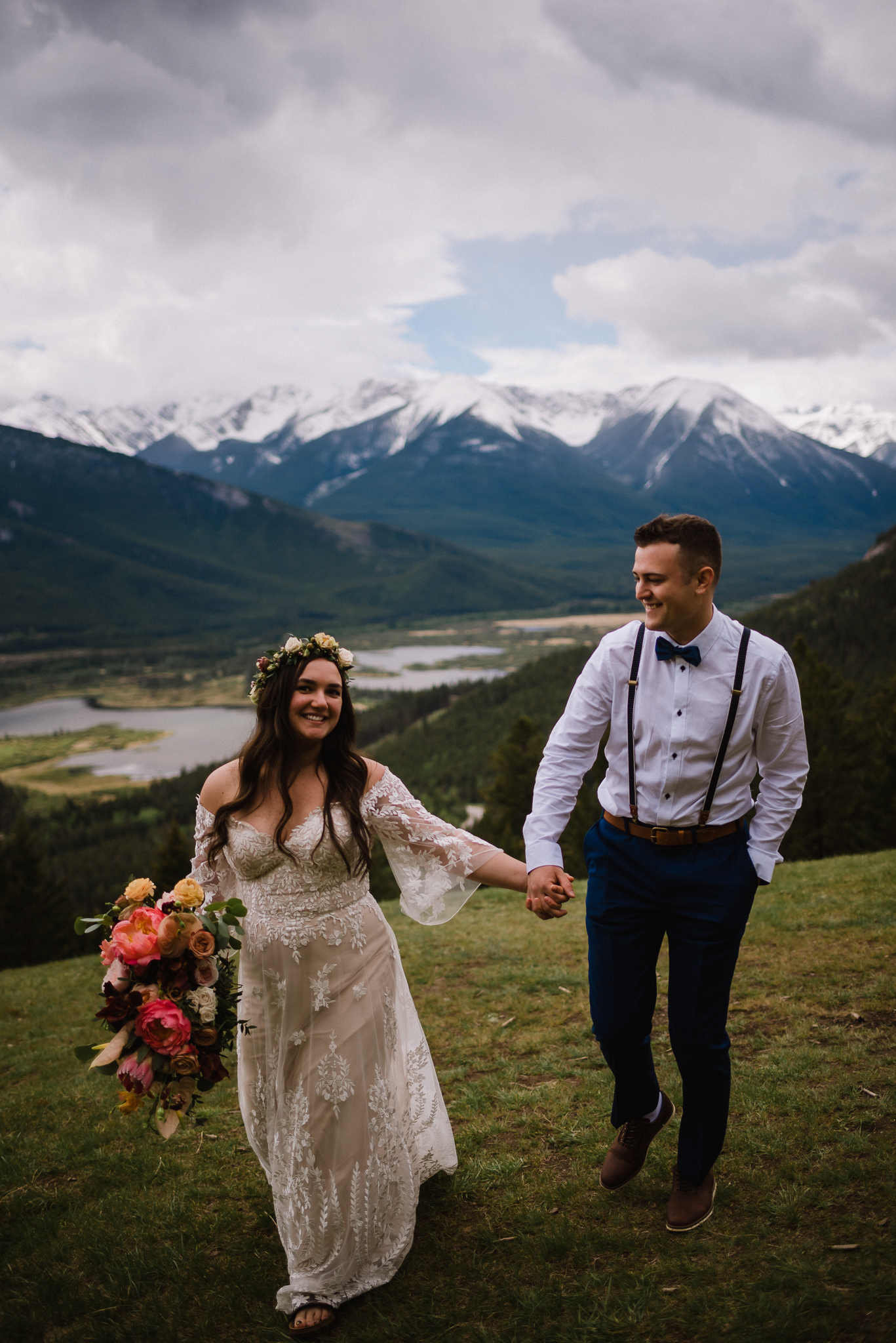 Bride and groom laughing and holding hands at Mount Norquay Lookout, Banff