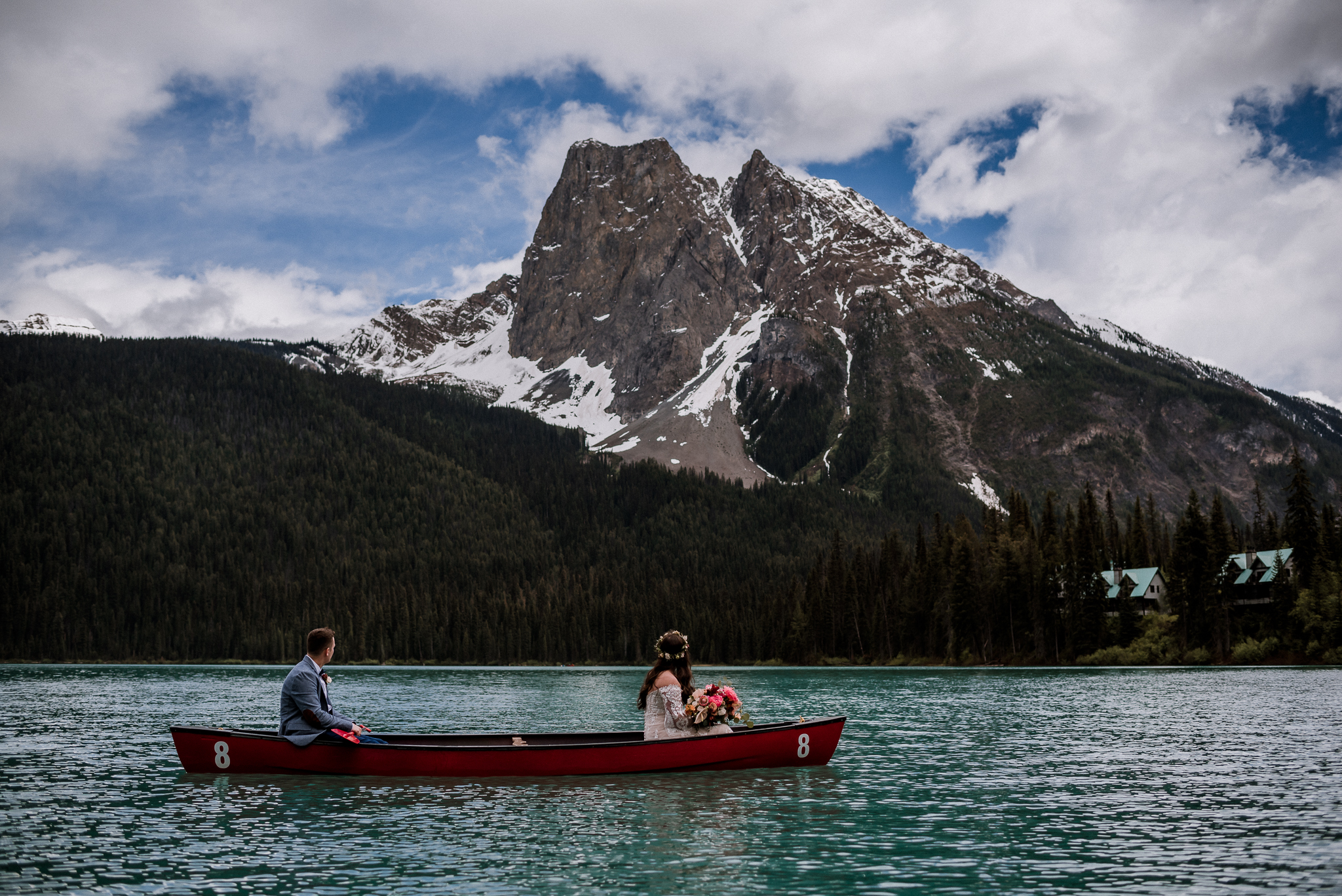Bride and groom in red canoe at Emerald Lake, BC