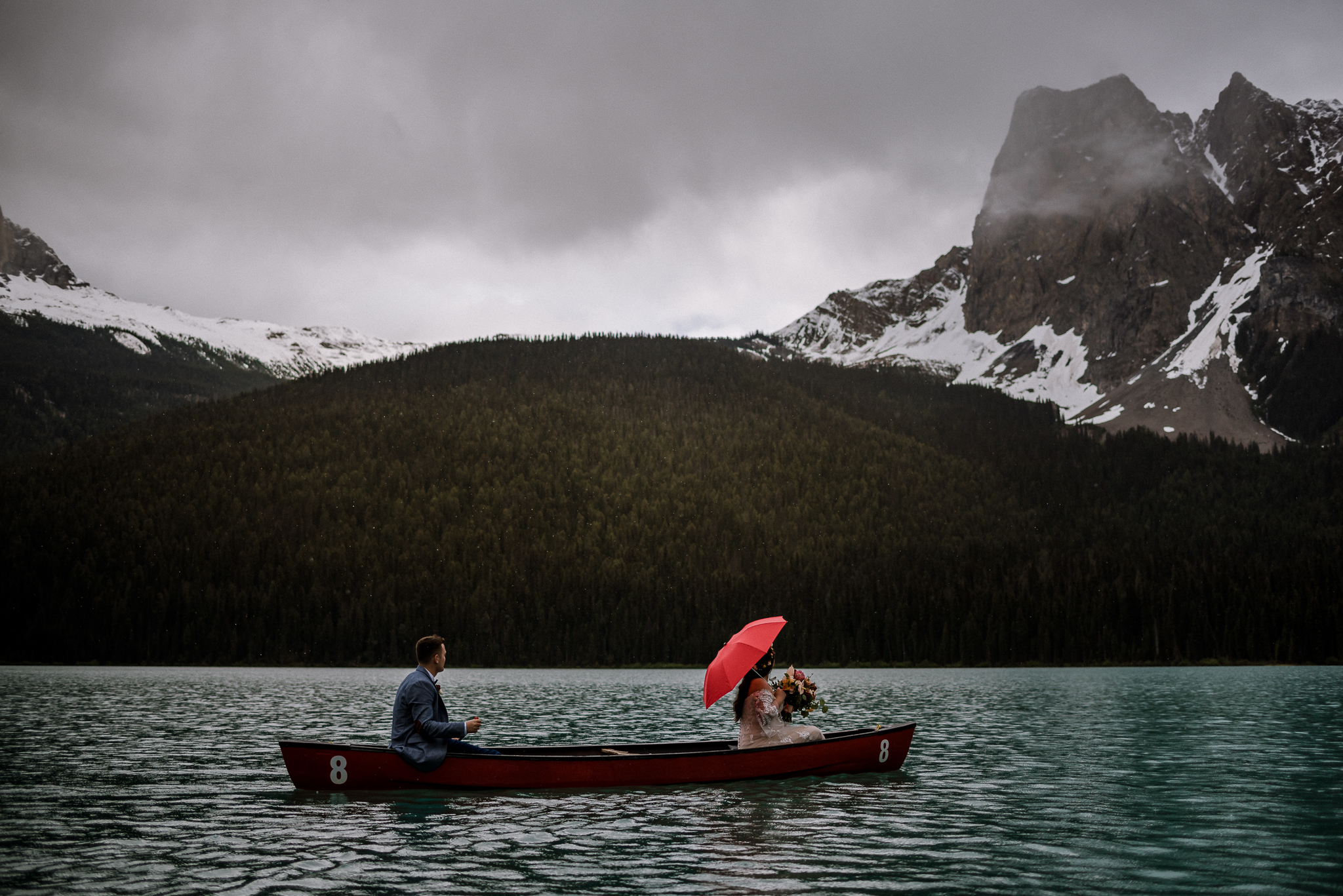 Bride and groom canoeing in the rain at Emerald Lake, BC