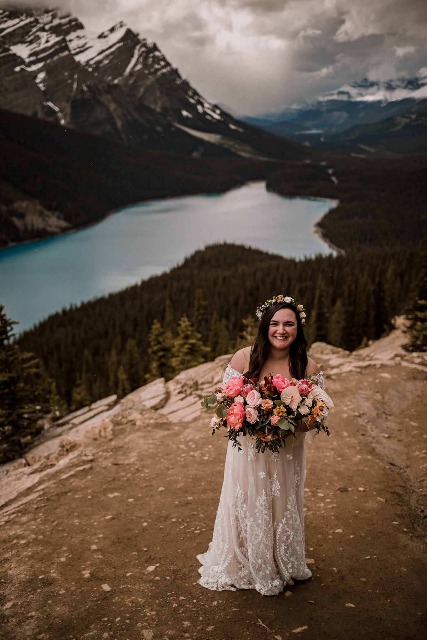 Bride holding bouquet laughing at Peyto Lake, Alberta