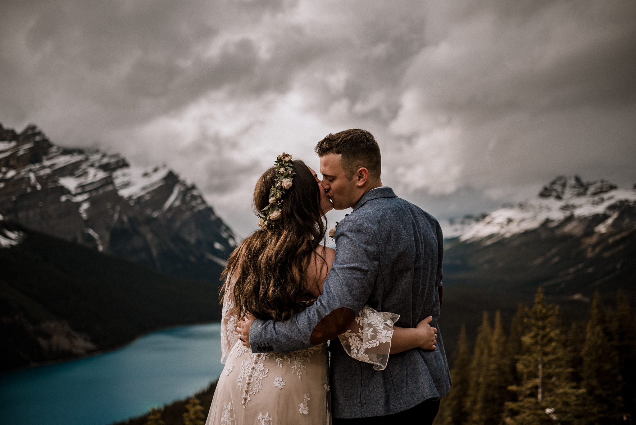 Bride and groom hugging and kissing at Peyto Lake, Alberta
