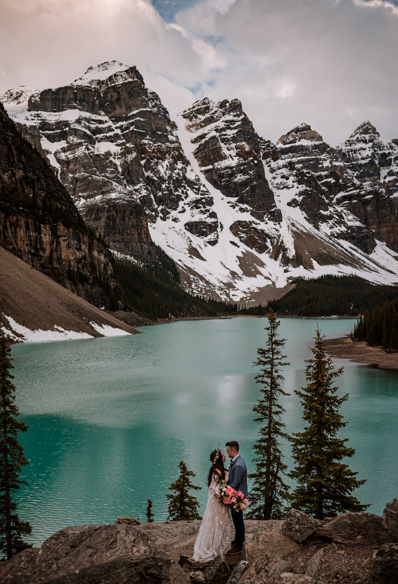 Bride and groom holding each other and looking in each others eyes at Moraine Lake, Alberta