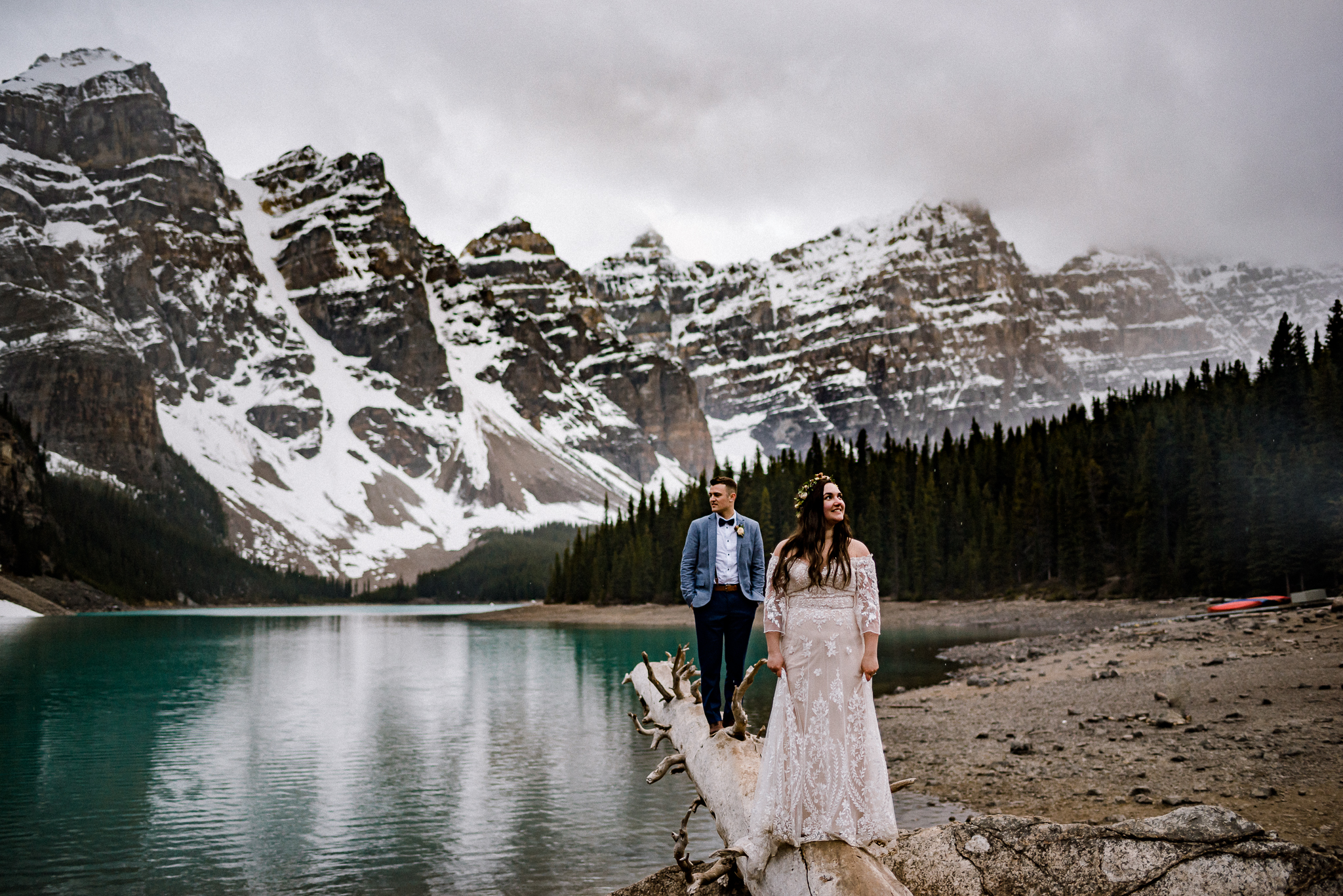 Bride and Groom standing on log at Moraine Lake, Alberta
